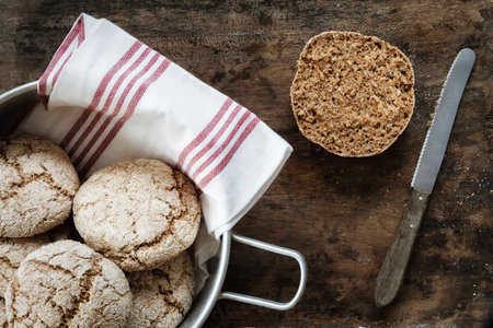 Homemade rye bread rolls on wooden plate and cooling grid