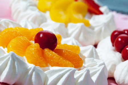 Three garnished meringue tartlets on pink cake plate, close-upの写真素材