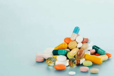 Various pills in heap on blue background, medicine conceptの写真素材