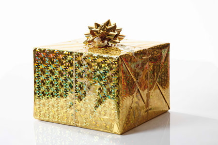 Christmas gift with golden bow on white background
