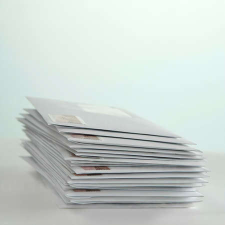 Stack of envelopes with stamps on the tableの写真素材