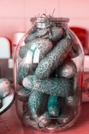 Fresh cucumbers in glass jar. Salting vegetables for winterの写真素材