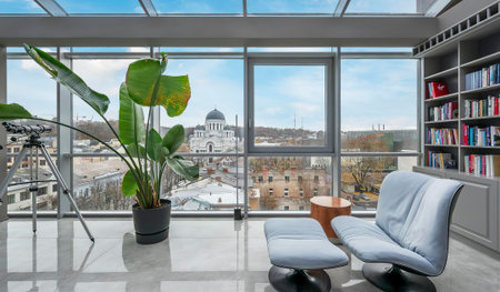 Interior of a modern living room with a large panoramic window overlooking the cityの写真素材