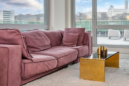 Modern living room interior with sofa, coffee table and window with city viewの写真素材