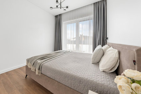 interior of modern bedroom with white walls, parquet floor and big bedの写真素材