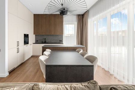 interior of modern bright kitchen with white walls, wooden floor and dining tableの写真素材