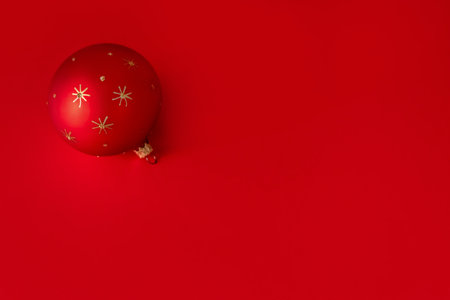 Red christmas ball on red background with copy space, top viewの写真素材