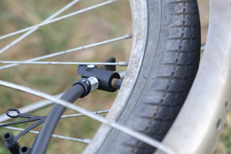 Close-up of bicycle tire inflating valve.Pump valve connected to the wheel.