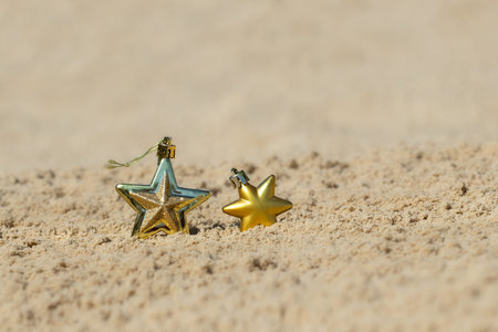 Gold and red christmas ornaments at the beach. For the concept of Christmas holidays in warm...