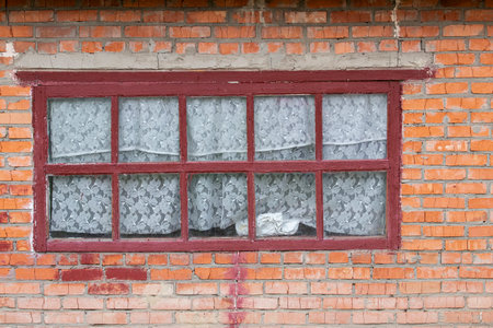 Old window in an abandoned house.An old window with a wooden frame in an abandoned rural house.The concept of destruction and desolation.の写真素材
