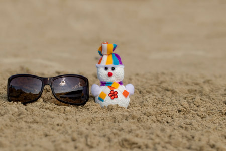 Christmas snowman.Toy snowman with sunglasses on the beach. Holiday concept can be used for New Year and Christmas Cards.の写真素材
