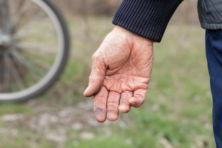 Cyclist repairing his bicycle.Dirty men's hands.Concept of repair and proper operation of bicycle.の写真素材