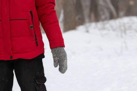 A man in warm clothes walks through a winter snow-covered forest.の写真素材
