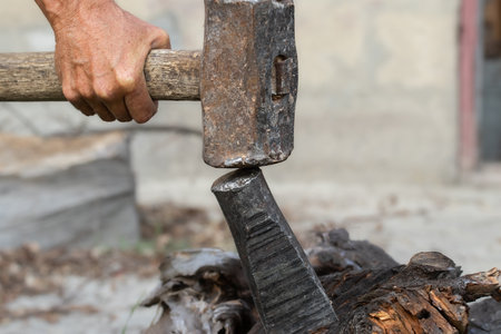 A man is trying to split a large stump.Harvesting firewood for the winter cold period.の写真素材