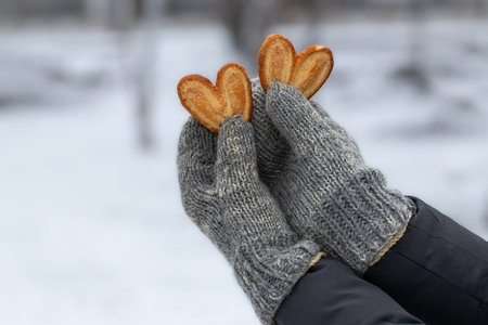 Two heart-shaped cookies in a woman's hands.The concept of love, friendship.の写真素材