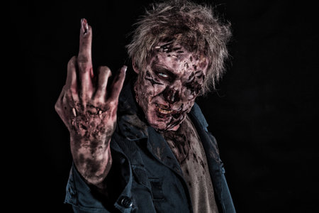 Scary Bloody Zombie Man with Glass in the Eye of Horror Halloween with a Hand and Broken Nails and...