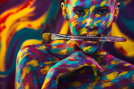 Portrait of the bright beautiful woman with art colorful make-up and bodyartの写真素材