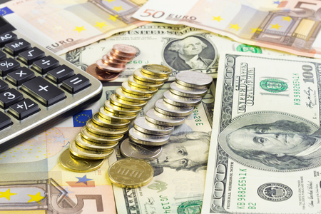 Calculator, money and coins laying on the tableの写真素材