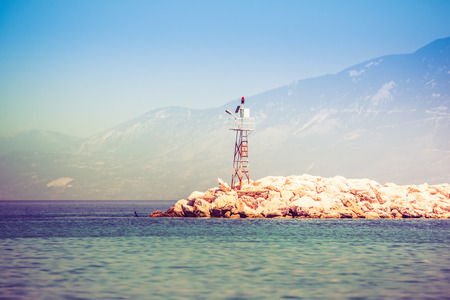 Rocky sea shore with beacon on sunriseの写真素材