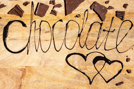 Inscription chocolate written with melted chocolate on wooden background, copy spaceの写真素材