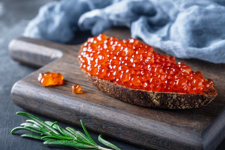 red caviar on bread, sandwich on a wooden boardの写真素材