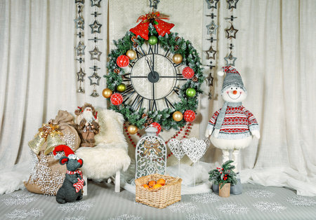 Christmas and New Year's interior with a large wall clock, decorated with toys, fir branches and garlands. New Year's gifts, expectation of a holiday in the house. Horizontally, copyspaceの写真素材