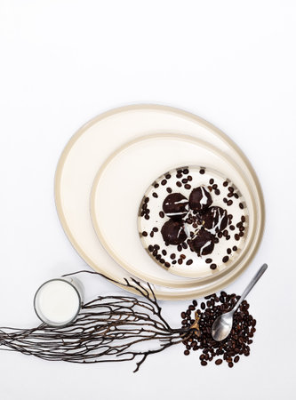 Chocolate chip cookies and black coffee grains on a dish on a white background,composition on the contrast of elements,  isolated, top view, flat lay, vertically, copyspase on the topの写真素材