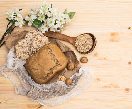 Products for a healthy diet (rye bread, cereals, walnuts, pumpkin seeds) laid out on a light wooden table against the background of burlap and rough paper, horizontal,  top view, flat layの写真素材