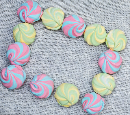 Colorful airy striped marshmallows on a knitted gray background,diagonal frame, close-up, flat lay, top view, horizotal, copyspace rightの写真素材