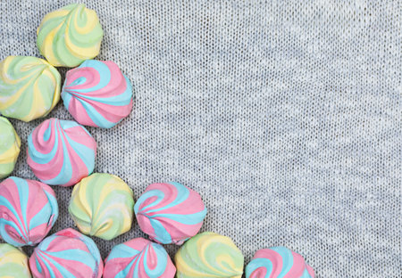 Colorful airy striped marshmallows on a knitted gray background, close-up, flat lay, top view, horizotal, copyspace rightの写真素材