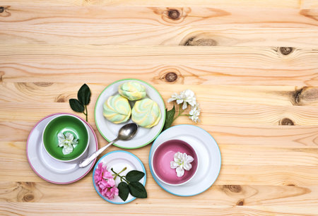 Colorful airy striped marshmallows on saucers on  a light wooden background, close-up, flat lay, top view, horizontally, copyspaceの写真素材