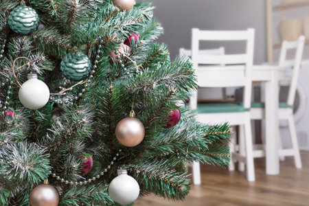 Christmas tree in the kitchen-living room with white chairs in the background, New Year's atmosphere of comfort, horizontalの写真素材