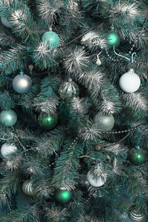 New Year and Christmas background from branches sprinkled with hoarfrost
  and elegantly decorated with  Christmas balls, beads, garlands. Vertical, close-upの写真素材