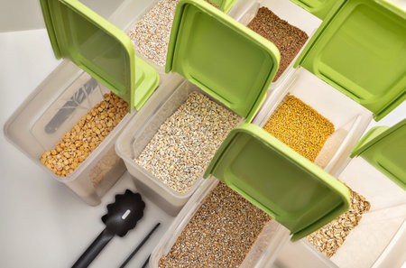 Various cereals - wheat, peas, buckwheat, millet, oatmeal, barley  in open plastic containers with...