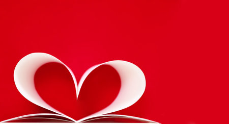 Graceful heart shape made of sheets of white paper on a red background, close-up, shallow depth of field, copy spaceの写真素材