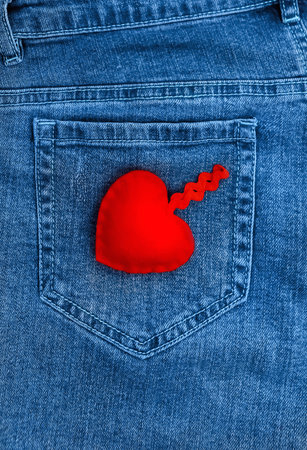 Soft valentine heart on the background of a jeans pocket, vertical, top view, copyspaceの写真素材