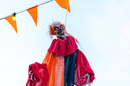 A creepy clown decoration hangs eerily from a string.