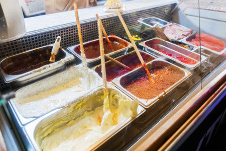 An assortment of delicious dipping sauces in stainless steel containers at a local deli. A variety...