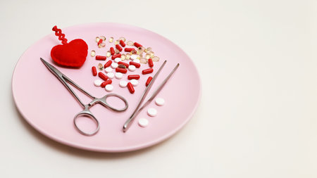 Medical tools and pills on a pink plate, well-lit with vibrant colors. Plate on white background for easy cropping. Ideal for health, hospital, surgery, medicine, pharmaceutical themes.の写真素材