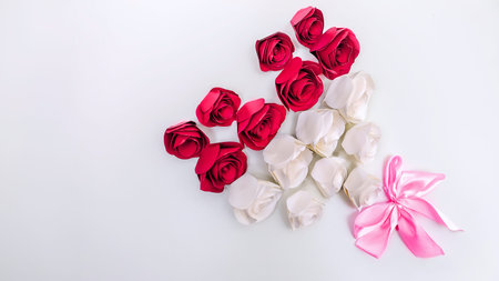 A beautiful arrangement of pink and white paper roses with a pink bow on a white background. Perfect for a wedding, birthday, or any special occasion. Isolated on a white background.の写真素材