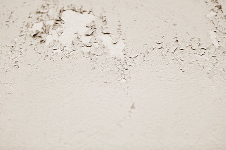A close-up view of a weathered white painted concrete wall texture with cracks and peeling paint, ideal for design projects, adding artistic flair and creative inspiration.の写真素材