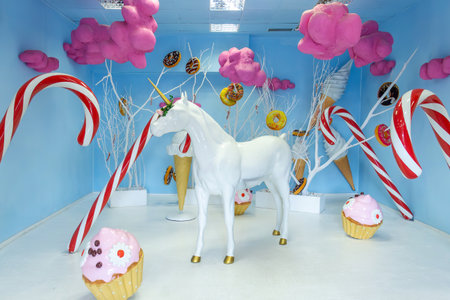 Bright pastel walls hold a whimsical scene filled with oversized candy decorations.の写真素材
