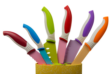 Kitchen ceramic-metal knives with bright handles on a special support with a silicone insertの写真素材