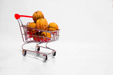 A small cart full of walnuts on a white backgroundの写真素材