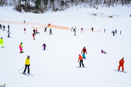 BUKOVEL, UKRAINE - December 17, 2016: Snowboarder and skiers enjoying on slopes of ski resort Bukovel. Bukovel is the most popular ski resort in Ukraine. Ski season and Winter sports conceptのeditorial素材