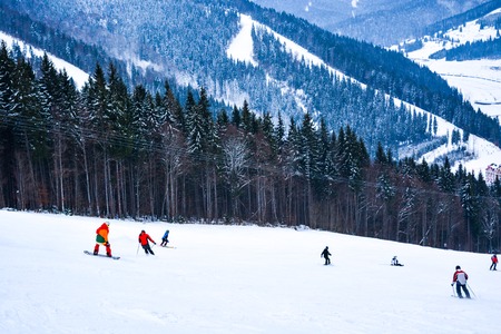 BUKOVEL, UKRAINE - December 17, 2016: Snowboarder and skiers enjoying on slopes of ski resort Bukovel. Bukovel is the most popular ski resort in Ukraine. Ski season and Winter sports conceptのeditorial素材