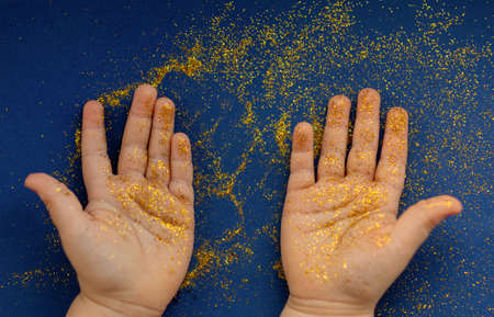 Opened little hands of kid covered by shiny glitter.の写真素材
