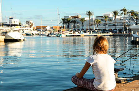 Teenager girl in meditation pose in marina of Formentera Island.の写真素材