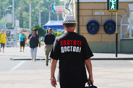 Belarus, Gomel- August 07, 2013 : Man walking in hat and black t-shirt with the inscription "Enough! I get it!" (translated from the Russian)のeditorial素材