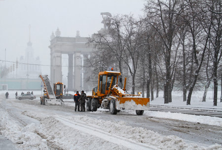 Moscow, Russia - January 13, 2016: Workers clean from the road snow near the entrance to VDNKh in Moscowのeditorial素材